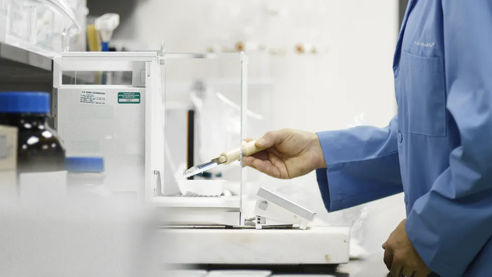 Herbalife Innovations and Manufacturing scientist measuring liquids in a lab