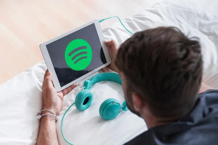 hombre-joven-sosteniendo-dispositivo-moderno-app-spotify_23-2147987830